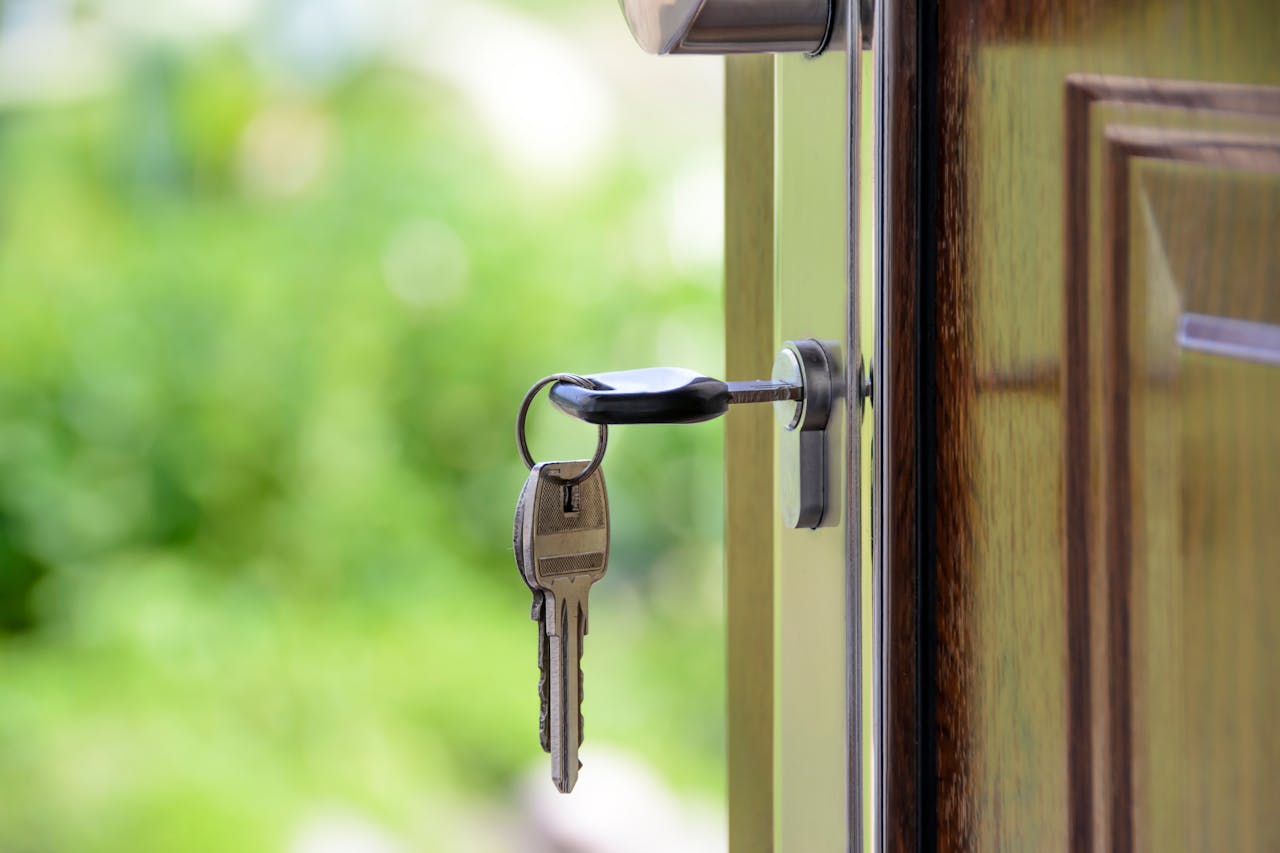 Home Key inserted in door lock against a blurred green background, symbolizing security and real estate.
