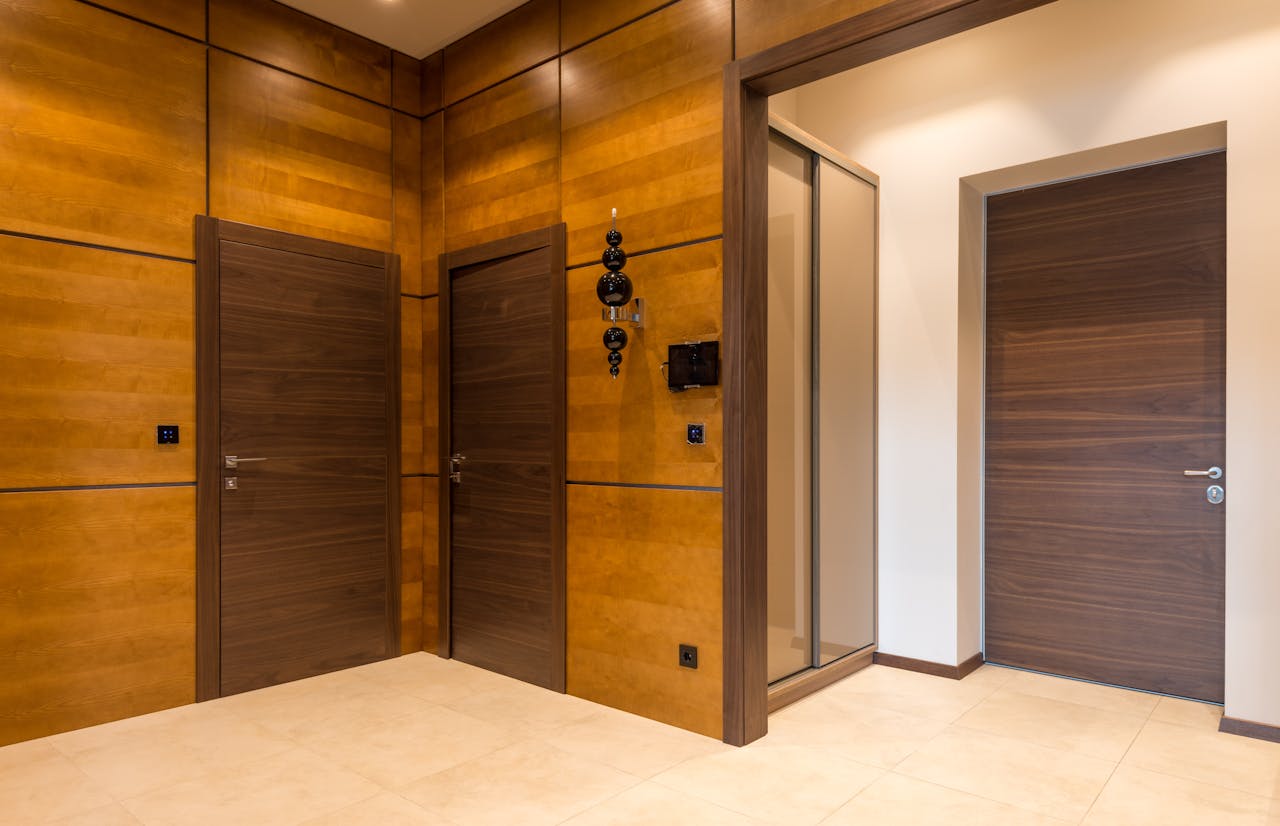 Services Contemporary room featuring sleek wooden doors and warm tones in a minimalist style.